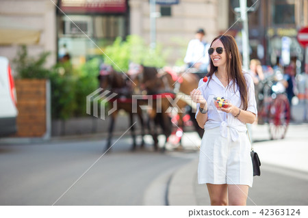 Tourist girl enjoying a stroll through Vienna and looking at the beautiful horses in the carriage 42363124