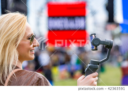 the girl with the phone on the stabilizer leads the videoblog. She takes herself to the camera 42363591