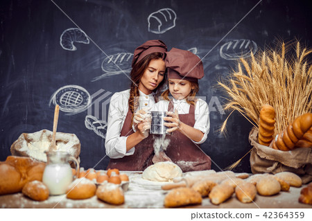 Woman and girl making pastries together Woman and girl making pastries together 42364359