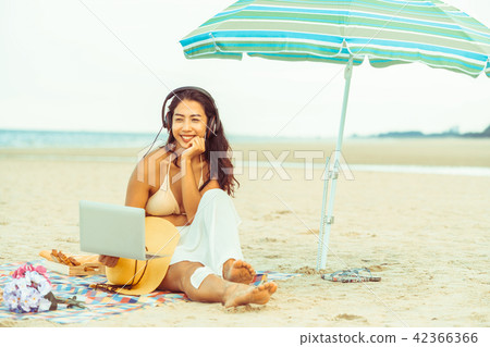 Plus size young woman sitting on the beach. 42366366