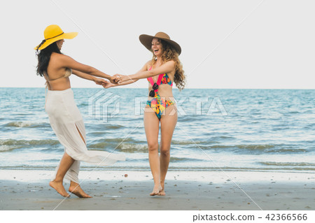 Happy women dance on sand beach in summer. Happy women dance on sand beach in summer. 42366566