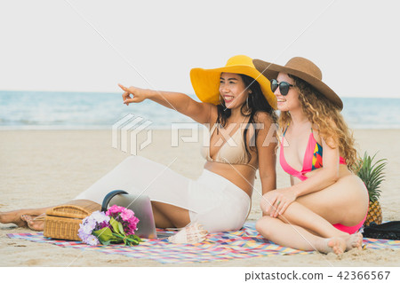 Happy women sitting on sand beach in summer. Happy women sitting on sand beach in summer. 42366567