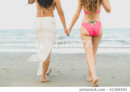 Happy women go sunbathing at sand beach in summer. Happy women go sunbathing at sand beach in summer. 42366569