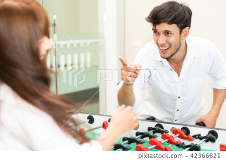 Happy couple playing foosball table. Happy couple playing foosball table. 42366621