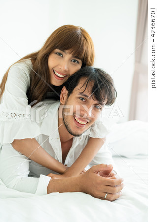 Happy young couple relaxing in the home bedroom. Happy young couple relaxing in the home bedroom. 42366701