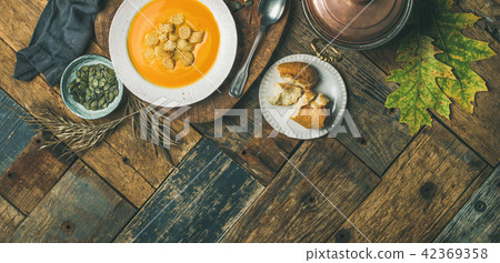 Fall pumpkin cream soup with croutons and seeds, wide composition Fall pumpkin cream soup with croutons and seeds, wide composition 42369358