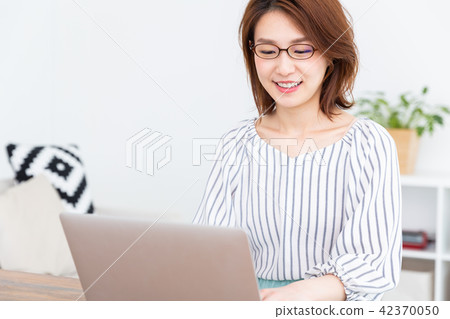 A woman watching a laptop computer in a room 42370050