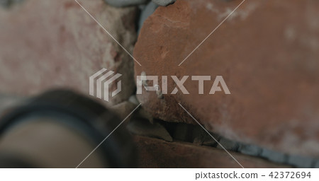 closeup of worker filling seam between bricks with mortar from sealant gun 42372694