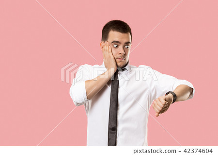 Handsome businessman checking his wrist-watch Isolated on pink background Handsome businessman checking his wrist-watch Isolated on pink background 42374604