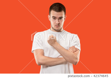 The young emotional angry man screaming on orange studio background The young emotional angry man screaming on orange studio background 42374645