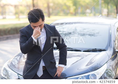 Businessman feel headache near his broken down car Businessman feel headache near his broken down car 42374859