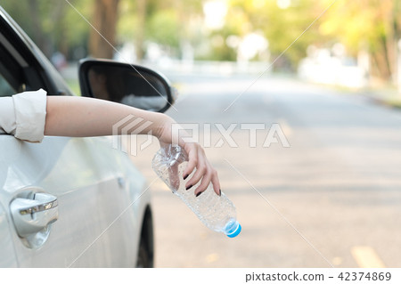 Hand throwing plastic bottle on the road Hand throwing plastic bottle on the road 42374869