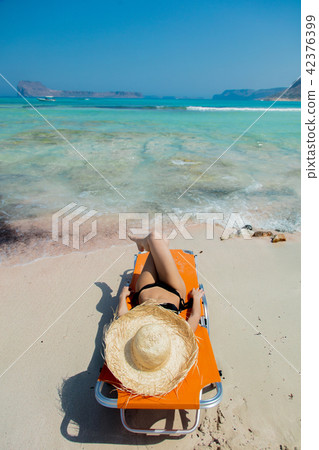 girl lying down on lounger on Balos beach 42376399