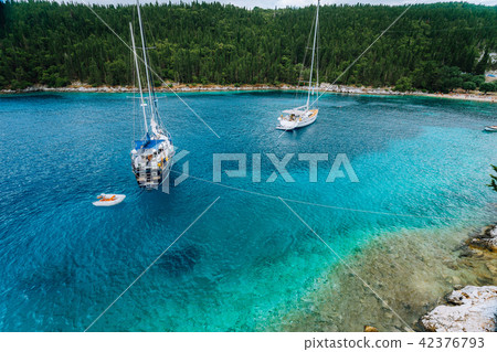 Crystal clear transparent blue turquoise teal mediterranean sea water of Foki Fiskardo Beach with Crystal clear transparent blue turquoise teal mediterranean sea water of Foki Fiskardo Beach with 42376793