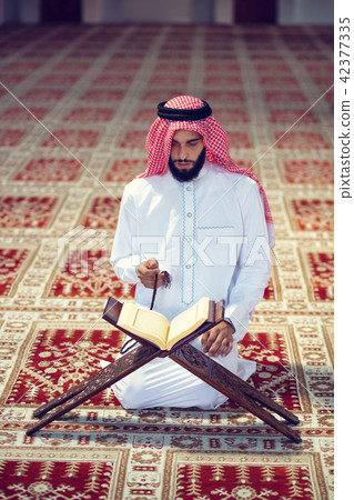 Religious muslim man praying inside the mosque Religious muslim man praying inside the mosque 42377335