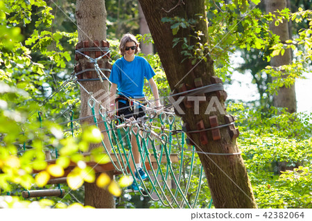 Teenager on rope way with zip line 42382064