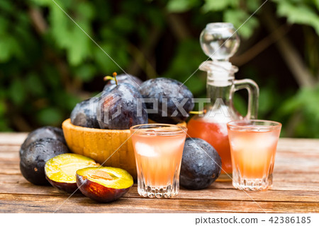 Plum brandy or slivovitz with fresh ripe plums Plum brandy or slivovitz with fresh ripe plums 42386185