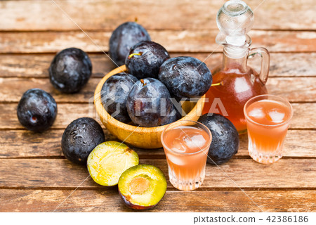 Plum brandy or slivovitz with fresh ripe plums 42386186