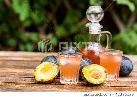 Plum brandy or slivovitz with fresh ripe plums Plum brandy or slivovitz with fresh ripe plums 42386189