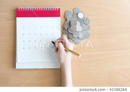 Hand writing in calendar plan and coins concept Hand writing in calendar plan and coins concept 42386269