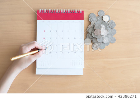 Hand writing in calendar plan and coins concept Hand writing in calendar plan and coins concept 42386271