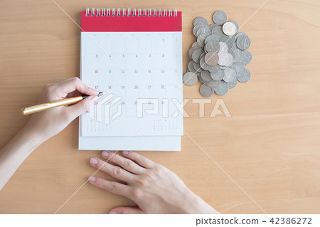 Hand writing in calendar plan and coins concept Hand writing in calendar plan and coins concept 42386272