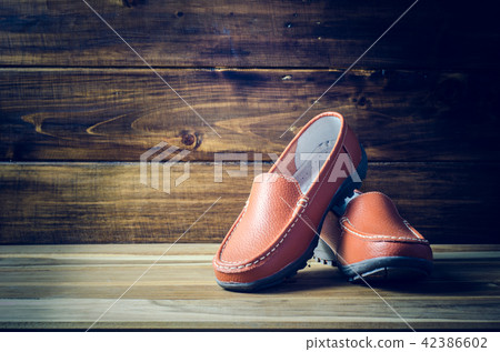 brown shoes on wooden floor brown shoes on wooden floor 42386602