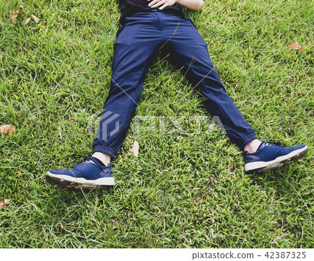 Man laying down on grass relaxing taking it easy Man laying down on grass relaxing taking it easy 42387325