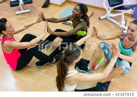 Cheerful woman clapping the hands in workout during group class  42387819