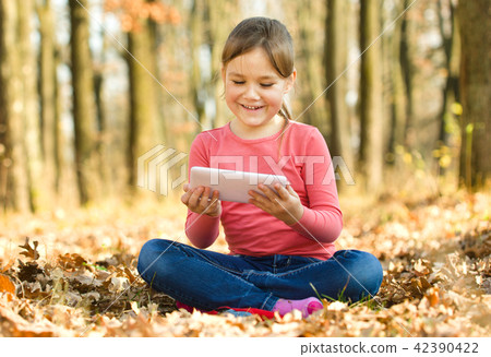 Little girl is reading from tablet Little girl is reading from tablet 42390422