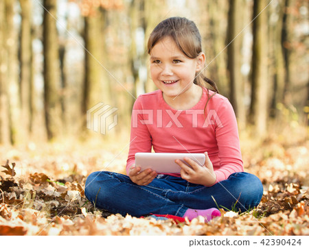 Little girl is reading from tablet Little girl is reading from tablet 42390424