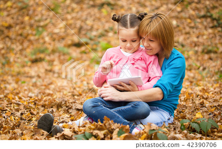 Mother is reading from tablet with her daughter Mother is reading from tablet with her daughter 42390706