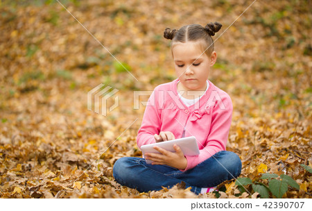 Little girl is reading from tablet Little girl is reading from tablet 42390707