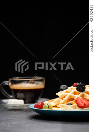 Photo of cup of coffee with sugar with Belgian waffles with strawberries, raspberries 42392482