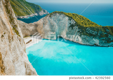 Famous shipwreck on Navagio beach with turquoise blue sea water surrounded by huge white cliffs 42392560