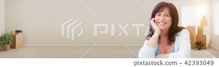 Banner of Middle Aged Woman Relaxing Inside Empty Room With Movi 42393049