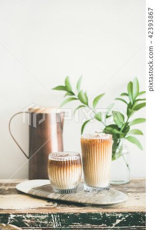 Iced coffee drink in tall glasses with milk on board Iced coffee drink in tall glasses with milk on board 42393867