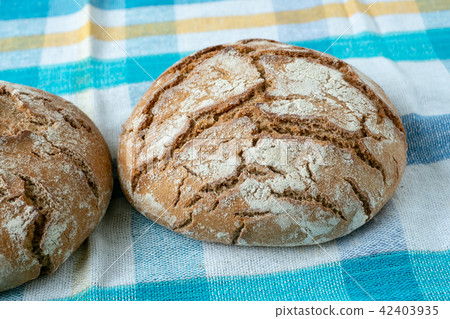 Fresh rustic bread on a checkered towel 42403935