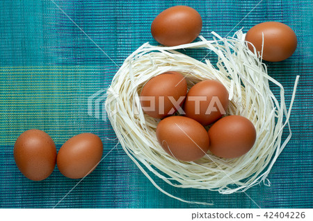 Eggs lie on the decor in the form of a nest. Eggs lie on the decor in the form of a nest. 42404226