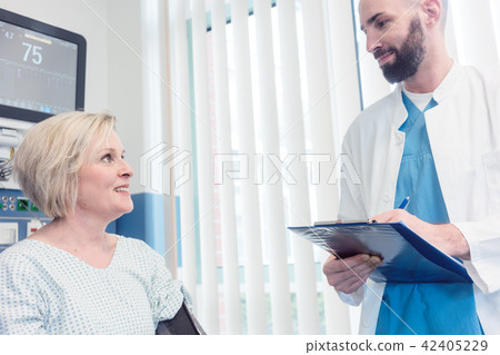 Doctor talking to patient in recovery room of hospital Doctor talking to patient in recovery room of hospital 42405229