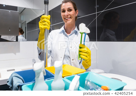 Janitor or charlady with her work tools looking at camera Janitor or charlady with her work tools looking at camera 42405254