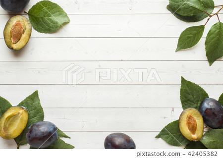 Fresh plum fruit with leaves on a light table 42405382