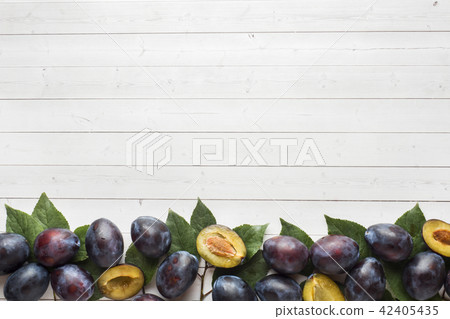 Fresh plum fruit with leaves on a light table 42405435
