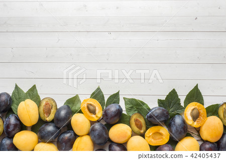 Fresh plum and apricot berries with leaves  42405437