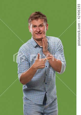 The young man whispering a secret behind her hand over green background The young man whispering a secret behind her hand over green background 42406193