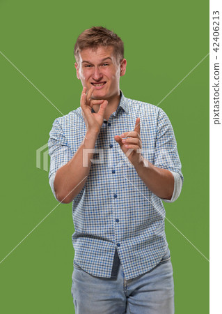 The young man whispering a secret behind her hand over green background The young man whispering a secret behind her hand over green background 42406213