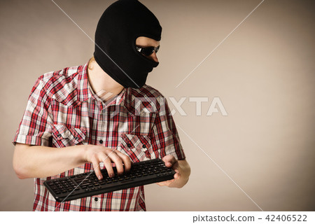 Man wearing balaclava holding keyboard 42406522