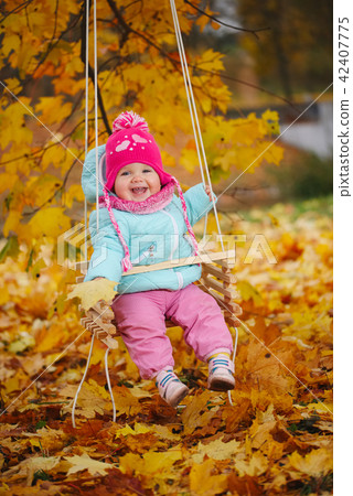 little girl on swings in autumn park little girl on swings in autumn park 42407775