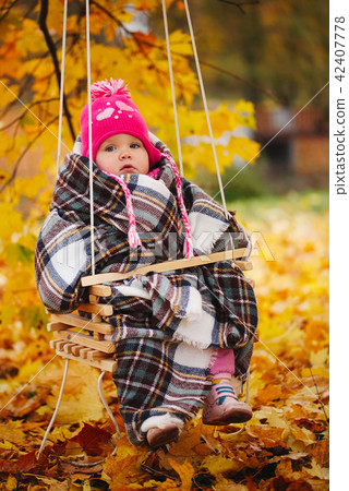little girl on swings in autumn park little girl on swings in autumn park 42407778