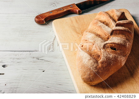 Rye loaf on cutting board with knife. Rye loaf on cutting board with knife. 42408829